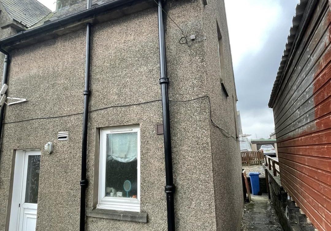 Rear of a rendered house with windows on a regular window cleaning round in Edinburgh