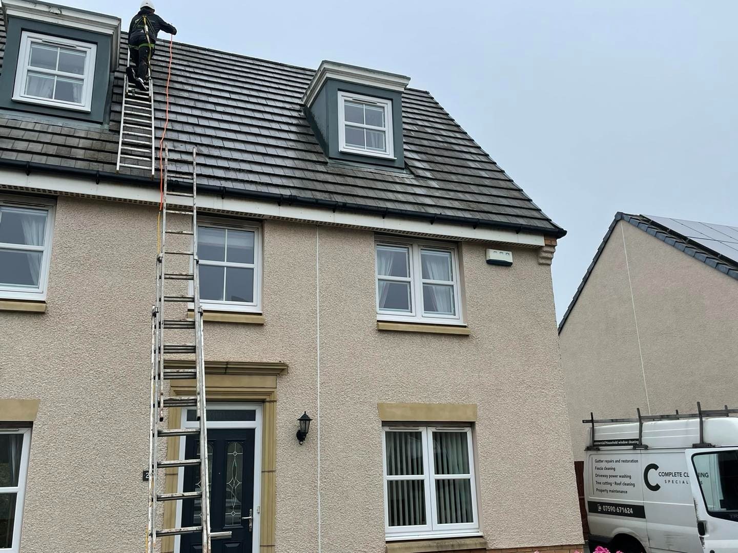 Ladder set up for hand roof cleaning on a detached house in Edinburgh