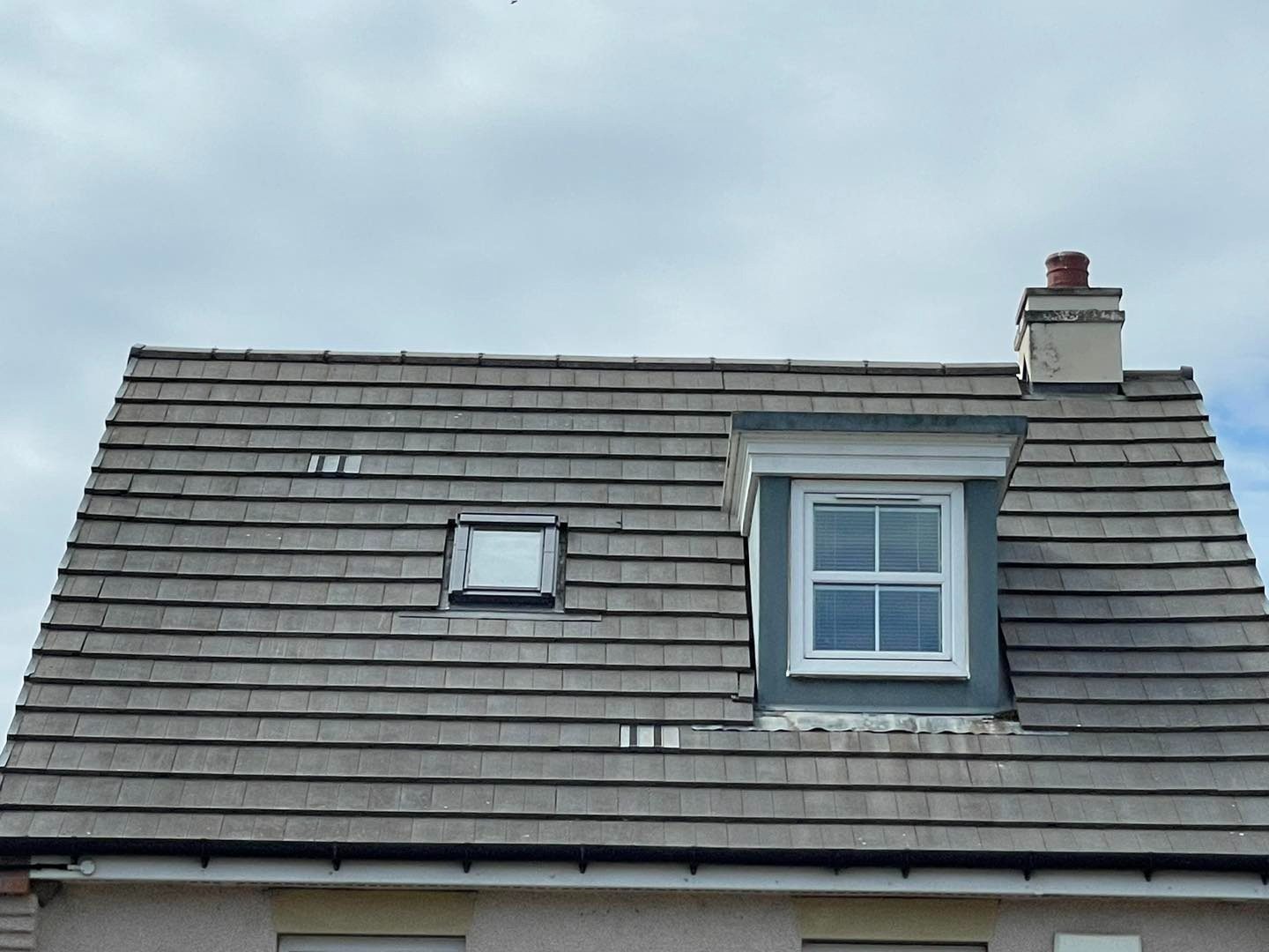 Grey tiled roof with dormer after biocide moss treatment in Midlothian